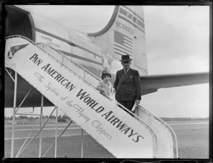 Portrait of Miss Dorothy Lesley Nicholson with grand father boarding PAA Clipper Celestial NC 88959 passenger plane, Whenuapai Airfield, Auckland