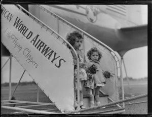 Portrait of the Rouda family children on PAWA boarding steps prior to departing on PAA Clipper Celestial NC 88959 passenger plane, Whenuapai Airfield, Auckland