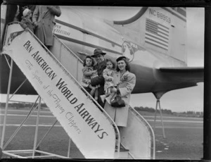 Portrait of Mr and Mrs Rouda and family boarding PAA Clipper Celestial NC 88959 passenger plane, Whenuapai Airfield, Auckland