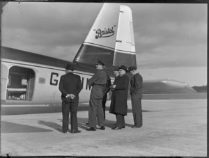 View of Mr T O'Connell in uniform and Mr J A C Allum (Mayor of Auckland) with unidentified men viewing visiting Bristol Freighter transport plane 'Merchant Venturer' G-AIMC with side cargo doors open, Whenuapai Airfield, Auckland