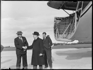 View of (L to R) J B O'Loghlen shaking the hand of J A C Allum (Mayor of Auckland) with M F Elliott (Bristol Sales Representative) looking on, in front of visiting Bristol Freighter transport plane 'Merchant Venturer' G-AIMC, Whenuapai Airfield, Auckland City