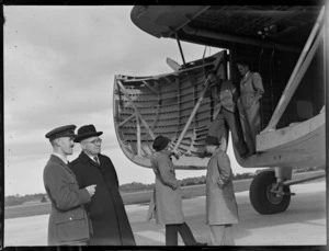 View of Mr T O'Connell in uniform and Mr J A C Allum (Mayor of Auckland) viewing visiting Bristol Freighter transport plane 'Merchant Venturer' G-AIMC with front cargo doors open, Whenuapai Airfield, Auckland