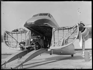 N Higgs' motorcar exiting a Bristol Freighter aircraft on arrival, Whenuapai, Auckland