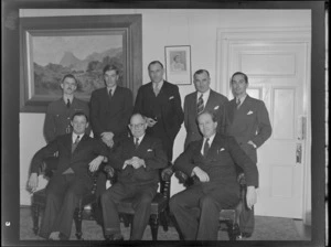 Unidentified men at a Mayoral reception for Bristol Freighter, including two paintings on the wall, one of Queen Elizabeth and the other of a bush scene, location unidentified