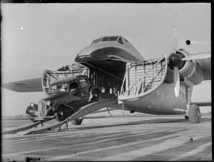 N Higgs' motorcar exiting a Bristol Freighter aircraft on arrival, Whenuapai, Auckland