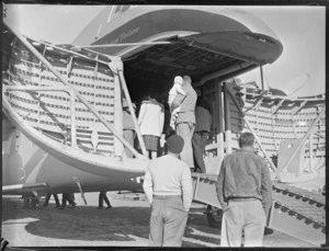 Crowd of people on a tour through a Bristol Freighter aircraft, Kaikohe, including a unidentified man holding a child