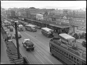 Wakefield Castrol Oil photographs, showing street scene in Newmarket, Auckland, including shops, buses, tram, motorcars and Rangitoto Island in the background