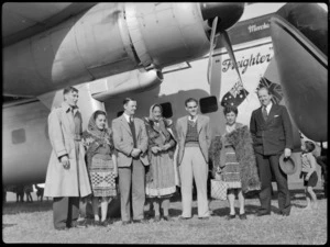 Crew members of Bristol Freighter Tour with guides, who are dressed in traditional Maori costume, and Mr N E Higgs, next to aircraft Bristol Freighter, at Rotorua, Bay of Plenty
