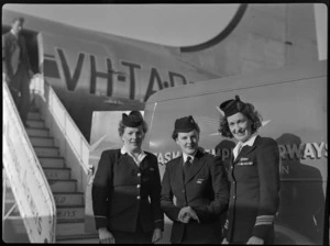 Flight attendants; Miss L Armstrong (left) of TAA (Trans Australia Airlines), Miss P Woolley of TEA (Tasman Empire Airways) and Miss M Harrison of TAA, standing in front of TEA catering van, including aircraft VH-TAD McDouall Stuart in the background, at Whenuapai Air Base, Auckland
