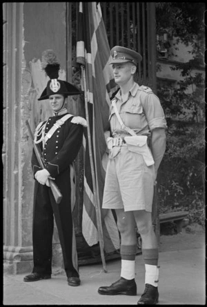British Military Police officer stands on guard with an Italian Carabinieri outside HQ in southern Florence, Italy, World War II - Photograph taken by George Kaye