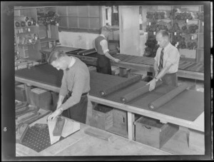 Three unidentified male employees at Parisian Neckwear Company Ltd, Auckland, working in the cutting room