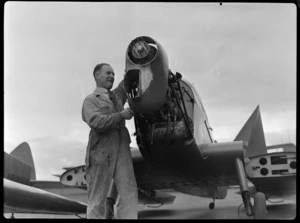 Mr J Ritchie overhauling the engine of a [de Havilland Moth Minor?] aeroplane, at Auckland Aero Club, Mangere, Manukau City, Auckland Region