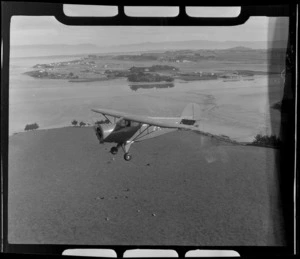 Rearwin Sportster aeroplane in flight over [Mangere?], Auckland