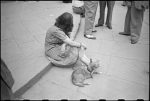 Italian woman and her dog rest in the street that is the part of Florence under Allied control, World War II - Photograph taken by George Kaye