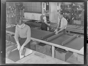Three unidentified male employees at Parisian Necktie Company Ltd, Auckland, working in the cutting room
