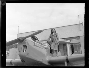Miss Stormont standing on the wing of an aircraft, at Auckland Aero Club, Mangere, Auckland