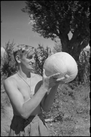 Cook, K J Truman, with locally grown pumpkin in the forward area Florence, Italy, World War II - Photograph taken by George Kaye