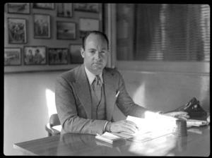 Portrait of Mr Whitney-Straight, sitting at a desk, during a BOAC (British Overseas Airways Corporation) visit to New Zealand, location unidentified