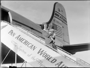 Air hostess, P Greaney holding unidentified baby, departing from Pan American Airways NC88944, Clipper Express aircraft