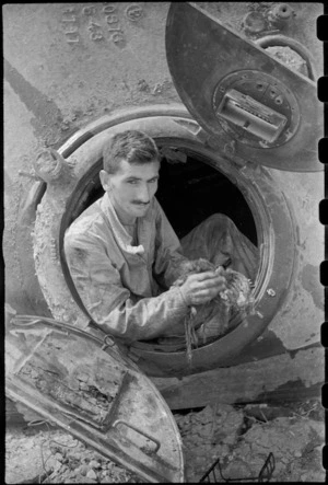 M W J McNicol finishes checking over interior of a World War II NZ Sherman tank near Florence, Italy - Photograph taken by George Kaye