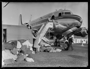 Airport ground crew unloading mail and freight from aircraft McDouall Stuart, TAA (Trans Australia Airlines), at Whenuapai Air Base, Auckland