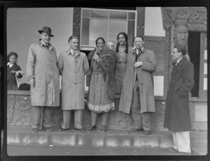 Unidentified members of Bristol Freighter crew, with guide Rangi, including young woman, toddler and child in background, [in front of a Wharenui?], Rotorua, Bay of Plenty region