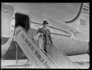 Mr Clapshaw, manager for Rendells [department store?], next to aircraft Douglas DC-4 Clipper Racer, PAWA (Pan America World Airways), unidentified location