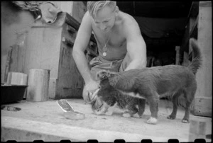 Cook J F Fleming feeds the unit mascot near Florence, Italy, during World War II - Photograph taken by George Kaye