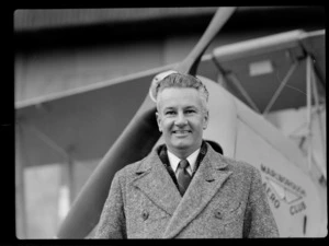 Bristol Freighter Tour, portrait of an unidentified man in front of a Marlborough Aero Club bi-plane at an unknown airfield, [Marlborough Region?]