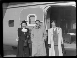 Bristol Freighter Tour, group portrait of two unidentified women with Bristol Freighter Navigator F E Sanders, in front of side cargo door of Bristol Freighter transport plane 'Merchant Venturer' G-AIMC, Harewood Airport, Christchurch City