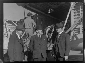 Bristol Freighter Tour, group portrait of S G Wild (Air Freight Control NZR), M H Grigg (District Traffic Officer) and C W S White (Goods Agent) in front of Bristol Freighter transport plane 'Merchant Venturer' G-AIMC, Harewood Airport, Christchurch City