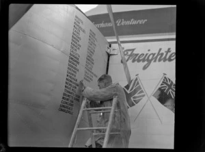 Bristol Freighter Tour, view of an unidentified Sign Writer adding the name of Christchurch to the nose cone of airports visited by the Bristol Freighter transport plane 'Merchant Venturer' G-AIMC, Harewood Airport, Christchurch City