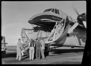 Bristol Freighter Tour, view of unidentified men loading ramps into the cargo bay of Bristol Freighter transport plane 'Merchant Venturer' G-AIMC, Paraparaumu Airport, North Wellington Region