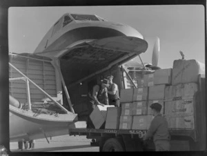 Bristol Freighter Tour, view of unidentified men loading freight off an NZR Road Services truck into the cargo bay of Bristol Freighter transport plane 'Merchant Venturer' G-AIMC, Paraparaumu Airport, North Wellington Region