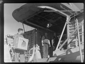 Bristol Freighter Tour, view of unidentified men unloading freight from front cargo bay off Bristol Freighter transport plane 'Merchant Venturer' G-AIMC, Harewood Airport, Christchurch City