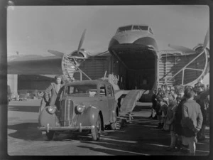 Bristol Freighter Tour, view of an unidentified woman with an unloaded car off Bristol Freighter transport plane 'Merchant Venturer' G-AIMC with children looking on, Harewood Airport, Christchurch City