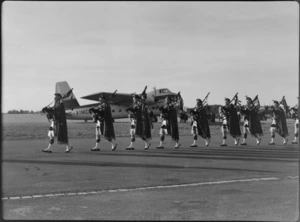 Christchurch Pipe Band, dressed in traditional Scottish costume, marching past a Bristol Freighter transport plane, G-AIMC, at Harewood Airport, Christchurch