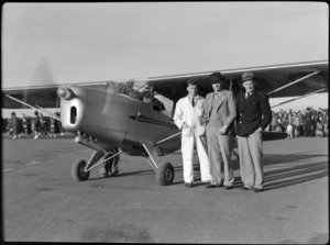 Mr CB Topliss, Mr W Hewitt, and Mr FJ Lucas, standing alongside Southern Scenic Airtrip's Auster aeroplane, [Harewood Airport, Christchurch?]