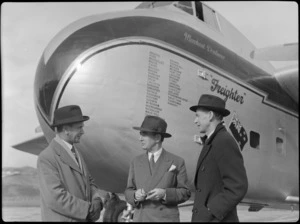 Three unidentified men standing in front of Bristol Freighter transport aeroplane 'Merchant Venturer', Rongotai Airport, Wellington