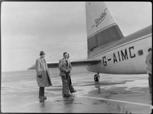 Sir Bernard Freyberg, Captain Ellison, and General P Edward Puttick (partly obscured), walking on tarmac at Rongotai Airport, Wellington, alongside Bristol Freighter transport aeroplane 'Merchant Venturer' G-AIMC