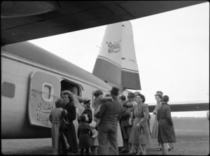 Bristol Freighter transport aeroplane 'Merchant Venturer', at New Plymouth Airport, showing unidentified men, women, and children embarking aircraft