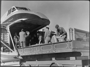Bristol Freighter transport aeroplane 'Merchant Venturer' being loaded with freight from the back of a New Zealand Railways Department Road Services truck, at Woodbourne Aerodrome, Marlborough District