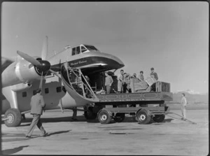 Group of unidentified men unloading cargo from Bristol Freighter transport aeroplane 'Merchant Venturer' at Woodbourne Aerodrome, Marlborough District, during Cook Strait trial