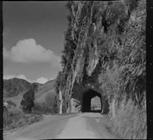 View of a road tunnel through a cliff with farmland hills beyond, Taumatamaire, Mahoenui District, Waikato Region