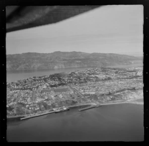 View of the Miramar Peninsula with Evans Bay and Shelly Bay Road with wharves in foreground to the eastern suburbs of Miramar and Strathmore, Wellington City