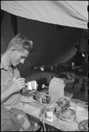 Dental mechanic, F W Ward, setting up a denture at the HQ of New Zealand Mobile Dental Unit in Italy, World War II - Photograph taken by George Kaye