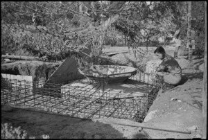 New Zealand soldier inspecting partially constructed enemy defence post in Riccione, Italy, World War II - Photograph taken by George Kaye