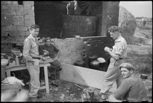 Informal group outside a 22 NZ Battalion cookhouse in forward areas near Rimini, Italy, during World War II - Photograph taken by George Kaye
