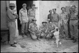 New Zealand and Greek troops watch antics of Greek mascot dog in forward areas near Rimini, Italy, World War II - Photograph taken by George Kaye