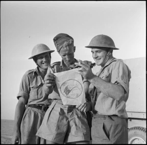 World War II New Zealand soldiers looking at German propaganda pamphlets on the Alamein front, Egypt - Photograph taken by H Paton
